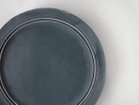 【ミシンポタリークリエーション/MISHIM POTTERY CREATION / GOODS】のStiLL round “year”plate S 2026 / スティル ラウンド イヤープレート S 2026(藍墨茶) 制作工程上、色を掛け流す際につく指跡や、絵の具の飛沫跡、細かな黒点(窯の中に残る鉄分が付着したもの)|ID:prp329100004773686